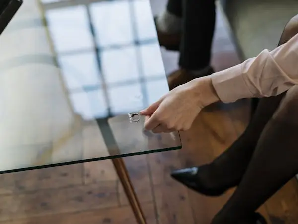 Woman placing wedding ring on table