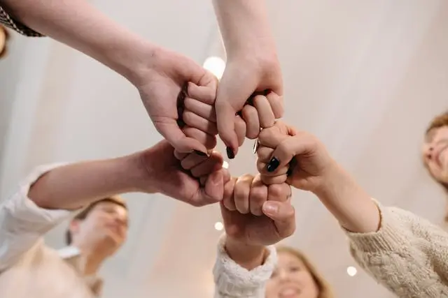 People in a circle touching fists